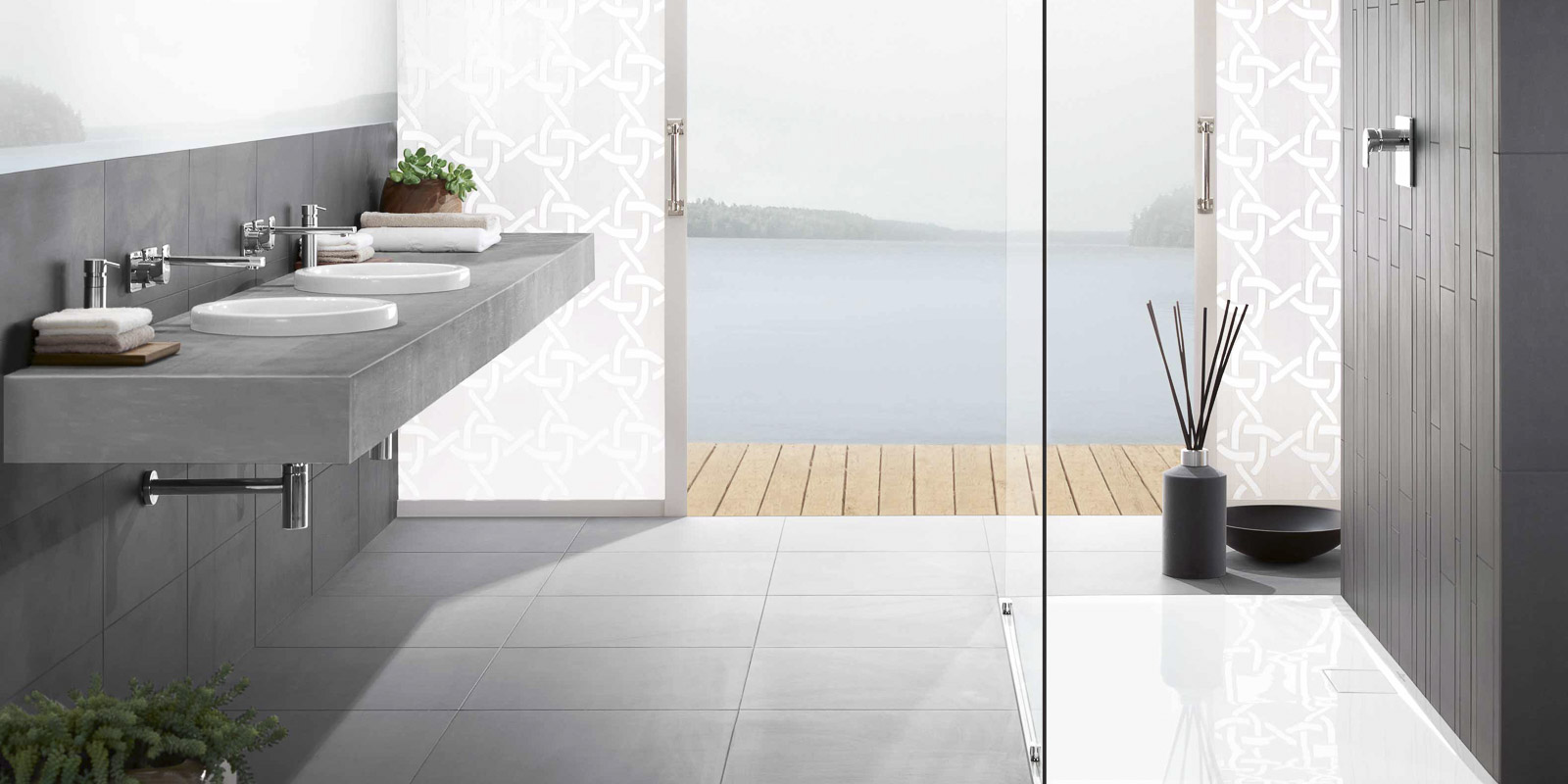 Ein modernes Badezimmer mit einem eleganten Waschbecken aus Beton und Blick auf einen ruhigen See durch große Fenster.