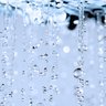 Faszinierende Tropfen, die im Licht funkeln Wassertropfen fallen in einer sanften Bewegung, während sie im Licht funkeln und eine ruhige Atmosphäre schaffen.