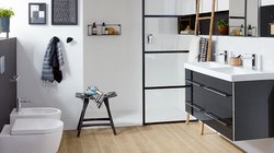 Ein modernes Badezimmer mit einem eleganten Waschbecken und einem großen Spiegel, umgeben von stilvollen Accessoires.