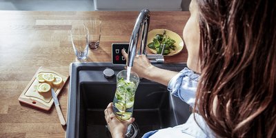 Erfrischendes Getränk mit Zitrone und Minze zubereiten Küchenspühle mit einem Display, ein Smarter Wasserhahn