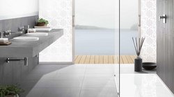 Ein modernes Badezimmer mit einem eleganten Waschbecken aus Beton und Blick auf einen ruhigen See durch große Fenster.